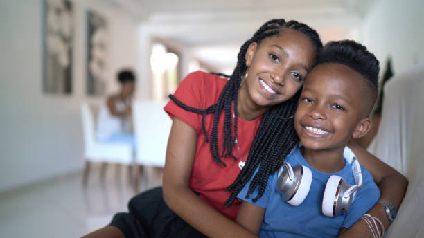 Home portrait of siblings embracing at home